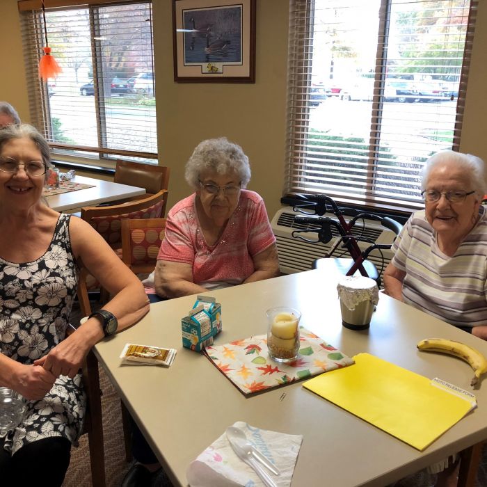 3 seniors smiling at table