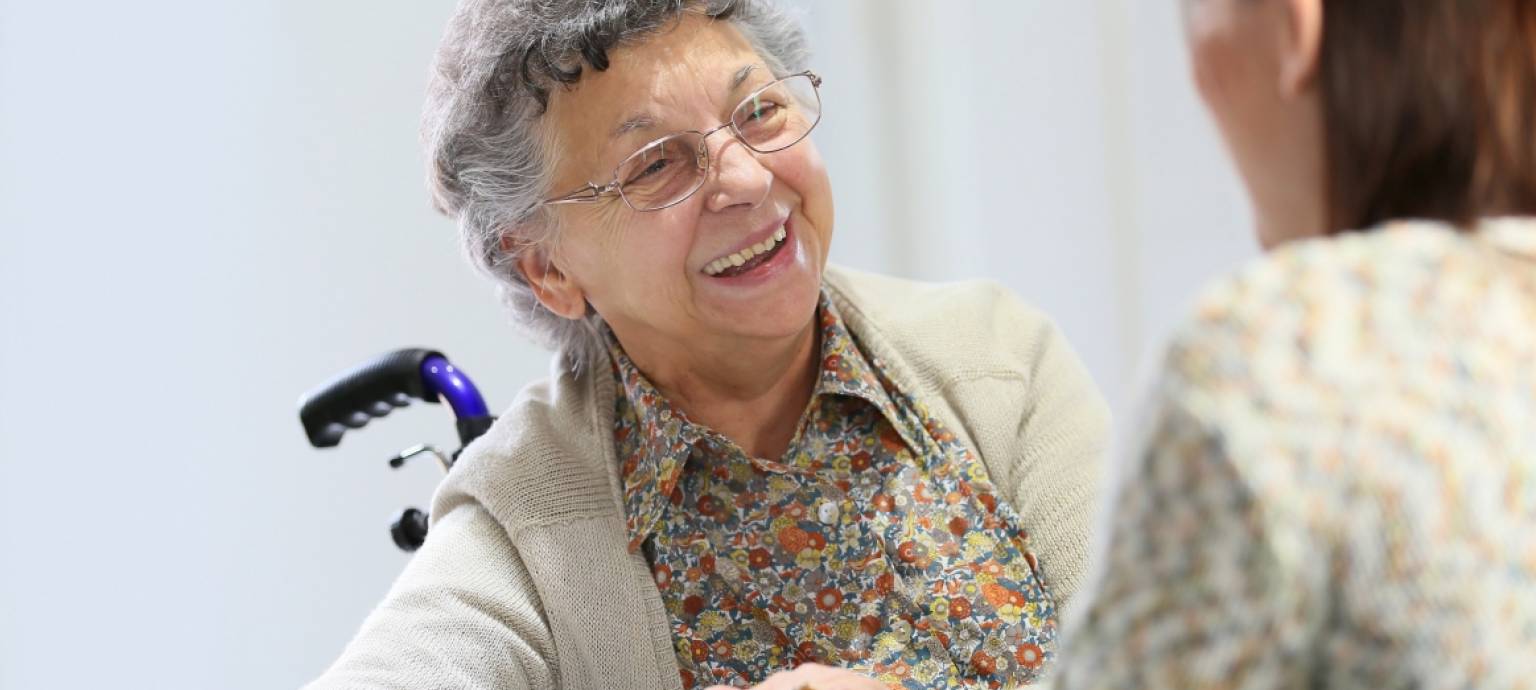 Masked elderly lady being handed bags at her front door