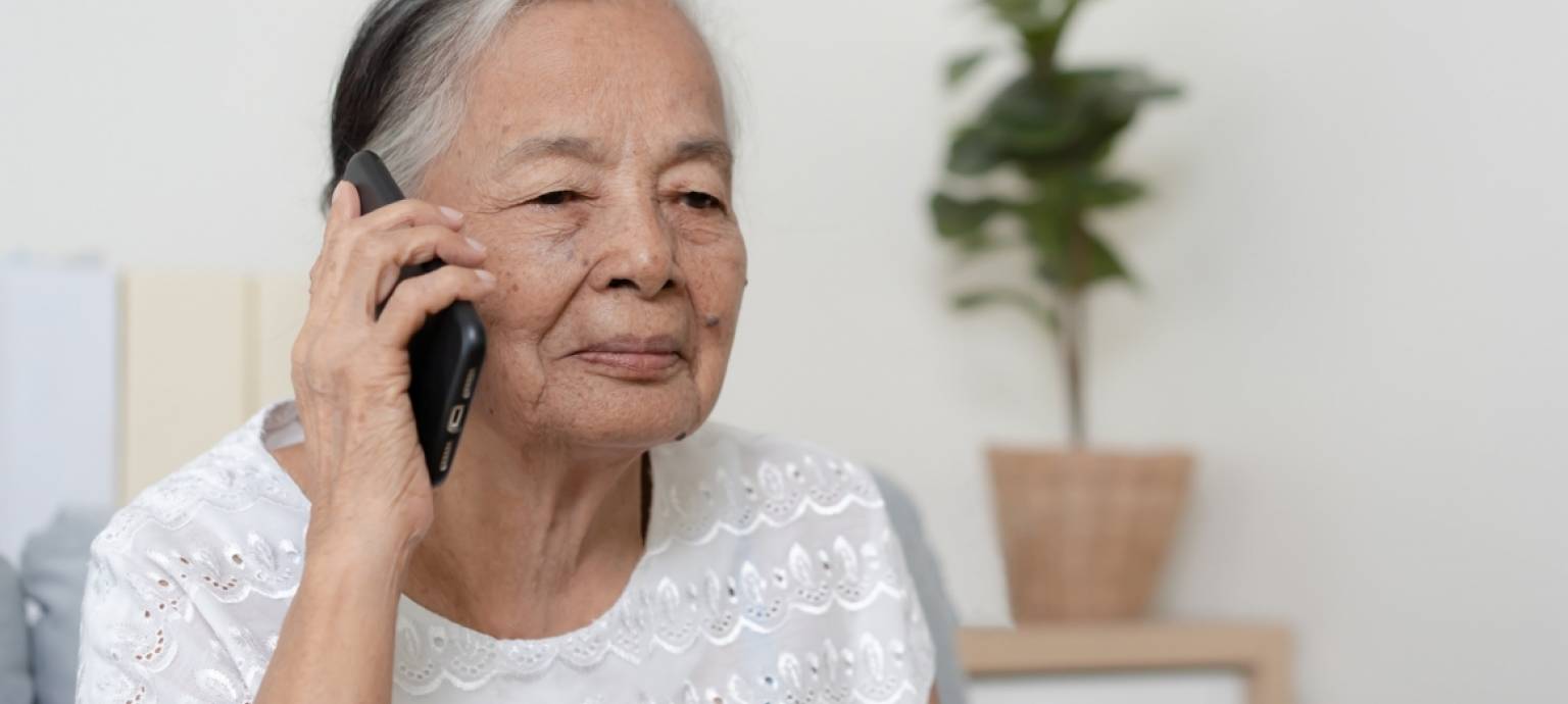 Old woman with cell phone up to her ear