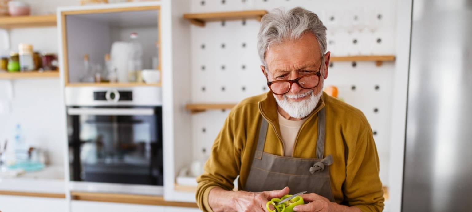Gray haired man preparing a healthy meal
