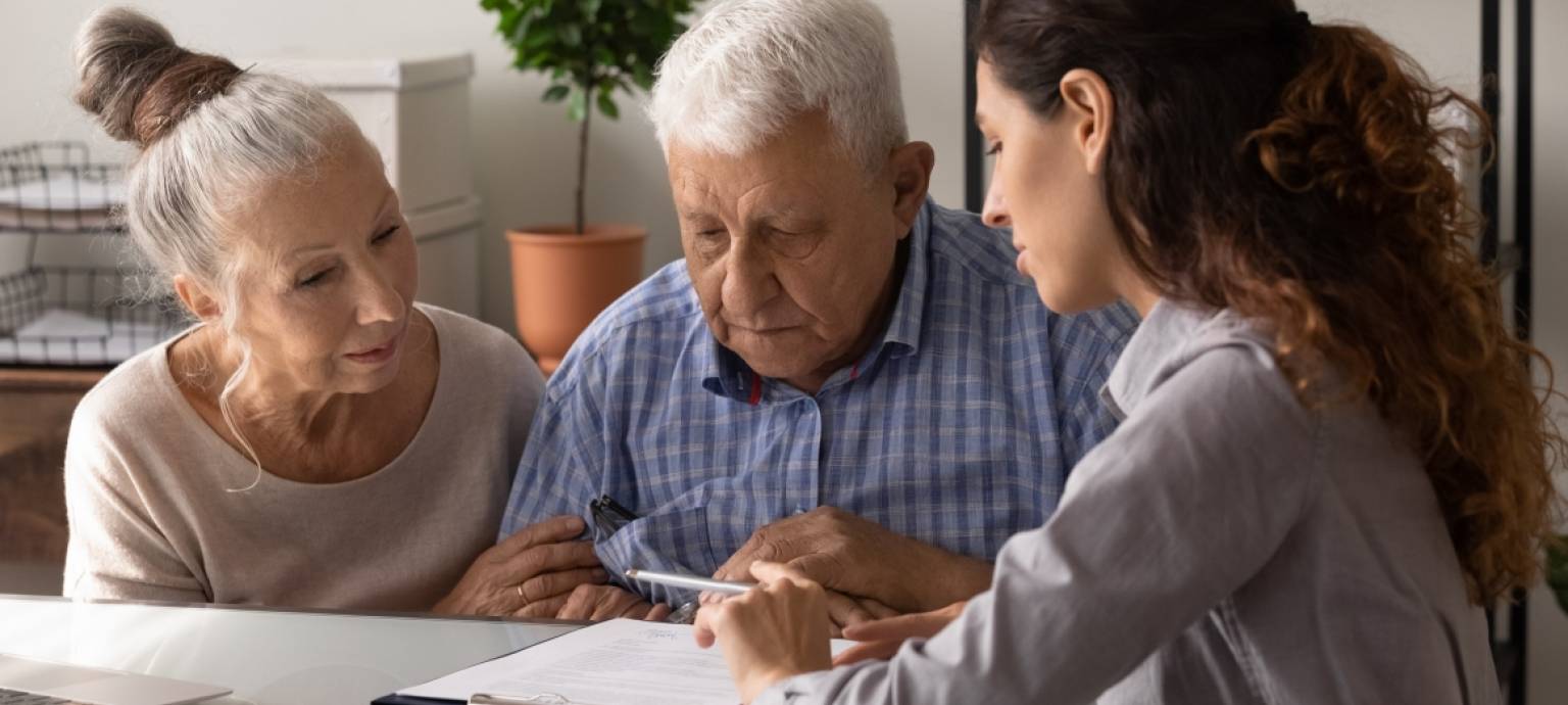 woman going over paperwork with older couple