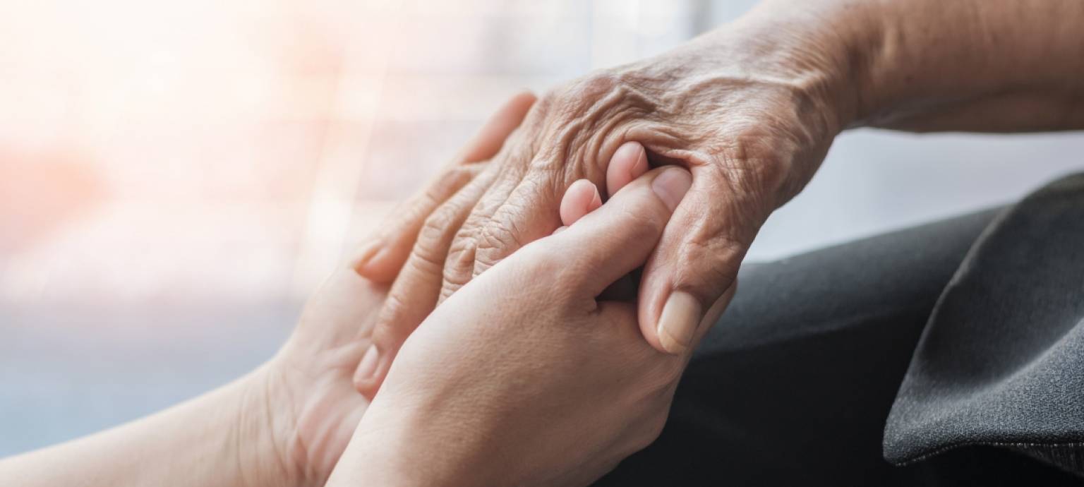younger hands holding elderly hands 
